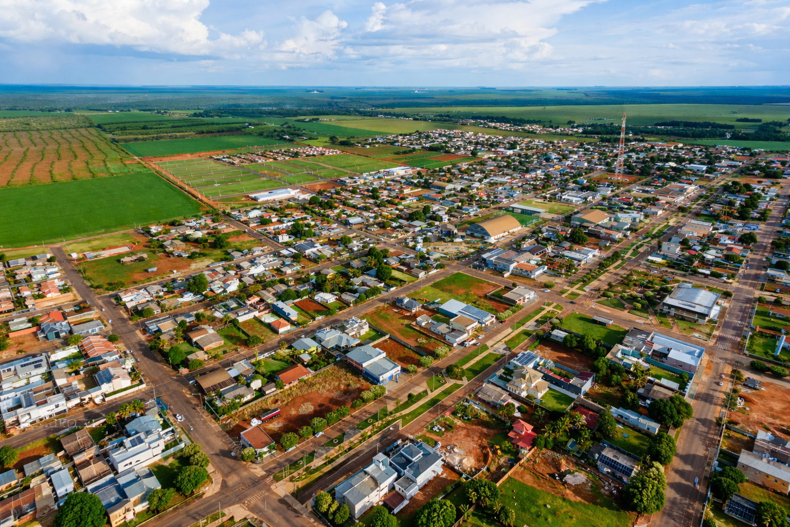 Vista aérea da cidade de Campos de Júlio no Mato Grosso cercada por extensas áreas agrícolas de soja e milho no interior do Brasil.